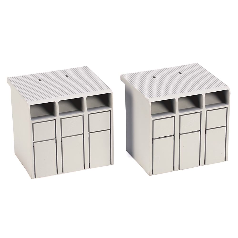 Two white modular terminal blocks with three vertical slots each, used for wiring connections on a electrical panel at a desk setup.