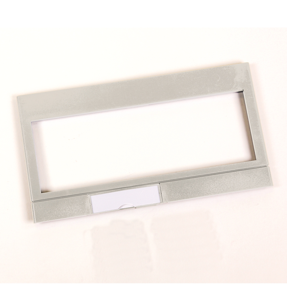 Silver rectangular metal frame with a large central opening and a small label slot at the bottom, looks like a name badge holder.