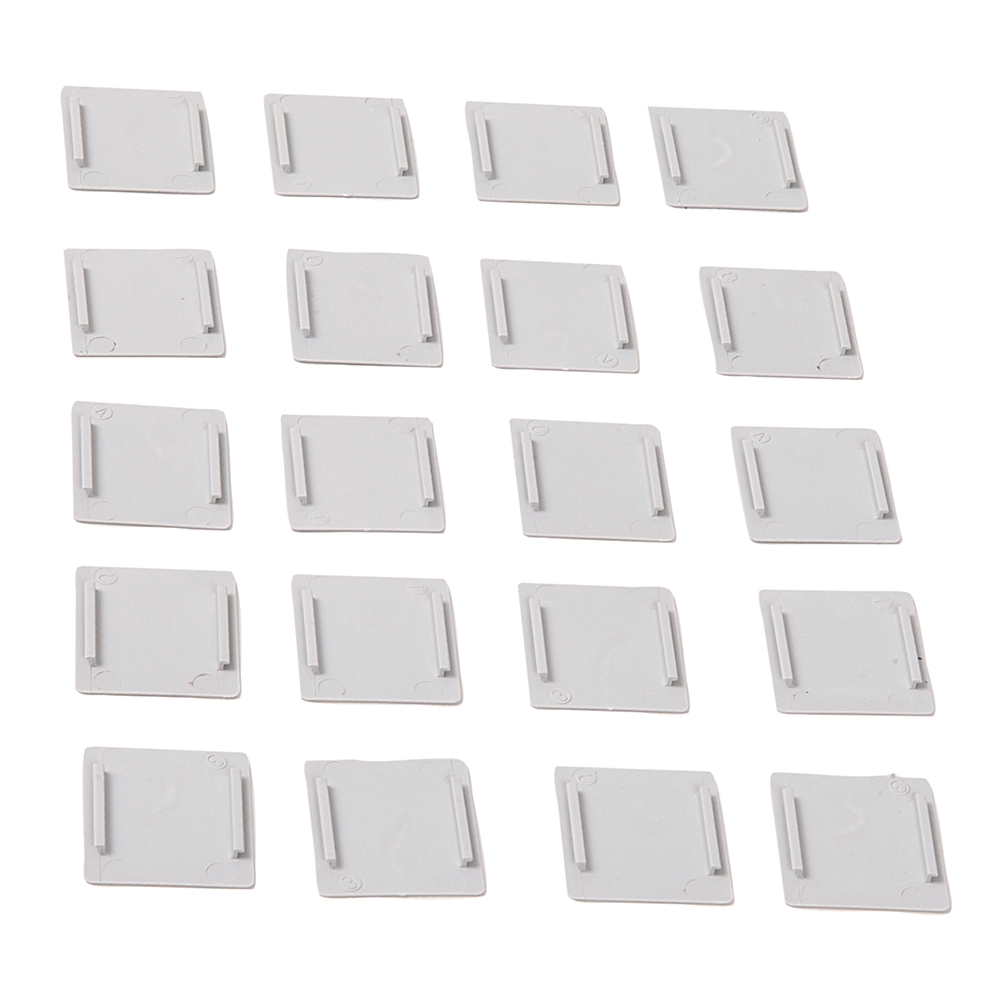 Twenty small white plastic rectangles with side grips arranged in a grid.