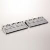 Two gray plastic cable raceways with vent slots and hinged lids resting on a white surface.