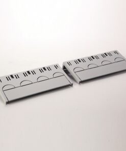 Two gray plastic cable raceways with vent slots and hinged lids resting on a white surface.