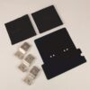 Assorted electronic components: two rectangular black plastic pieces, a larger black mounting plate with holes, and four silver metal contact strips with holes.