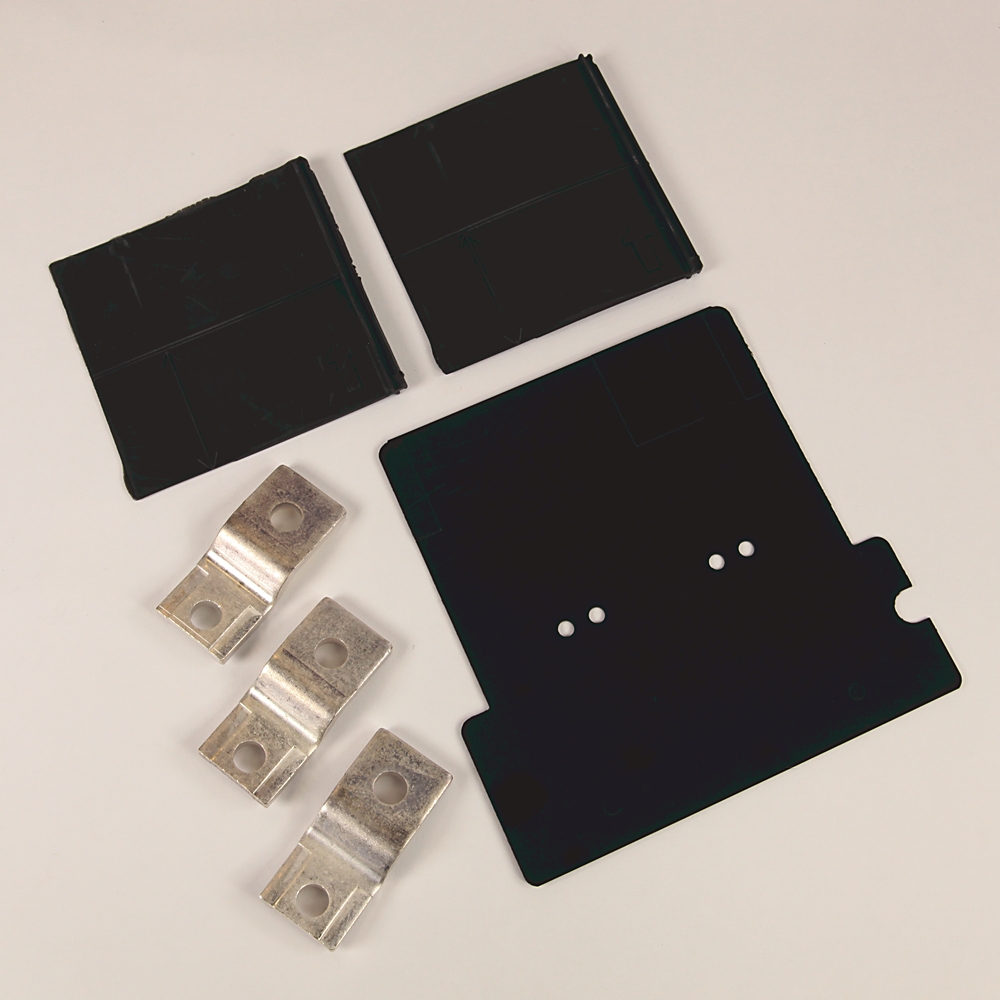 Assorted electronic components: two rectangular black plastic pieces, a larger black mounting plate with holes, and four silver metal contact strips with holes.