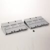 Two light-gray vented panels (server rack blanks) with curved cutouts, placed on a white surface with a few small black screws nearby