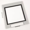 Gray square front bezel with an empty central opening, a row of screws to the left, and a blank label at the bottom.