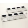 Two white 4-slot drive bay panels with square openings on a white background, with a few screws nearby.