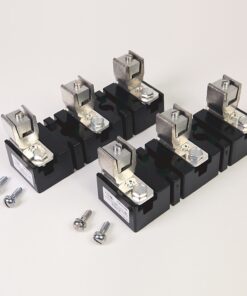 Six black electrical contactors with silver terminals and mounting screws laid on a light surface, plus loose screws nearby