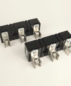 Eight black circuit breaker modules with silver terminal lugs arranged in two rows on a white surface