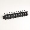 Row of black plastic screw-terminal blocks with metal clamps on a white background, used for wiring connections in panels.