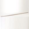 Long metal ruler with orange markings lying diagonally on a white surface, used for measuring.