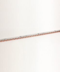 Long white ruler-like strip with orange teeth along one edge, laid diagonally on a white background.