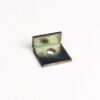 Metal L-shaped mounting bracket with a central hole, showing rusted rainbow patina on white background.