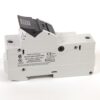 White miniature circuit breaker with a black toggle shown from the side, label visible on body.