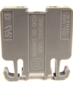 Gray plastic electrical connector block with two bottom hooks and a central warning label indicating safety instructions.