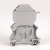 Back view of a gray modular electrical terminal block with mounting base and clamps.