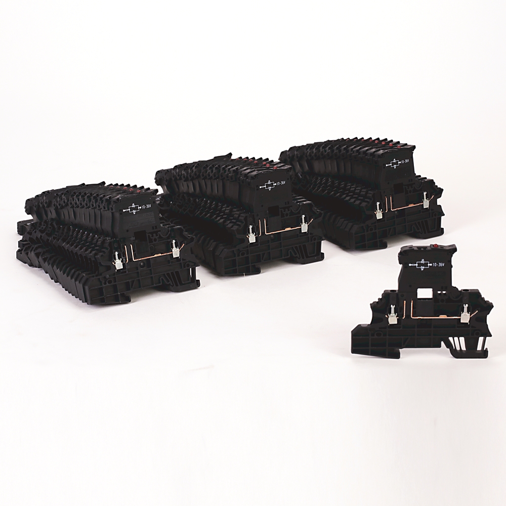Black modular electrical components with copper connectors arranged in rows on a white surface.