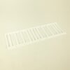 White plastic vent grille laid on a light surface with evenly spaced vertical slats