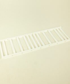 White plastic vent grille laid on a light surface with evenly spaced vertical slats
