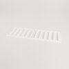 White plastic air vent grille with parallel rectangular slats lying on a pale surface