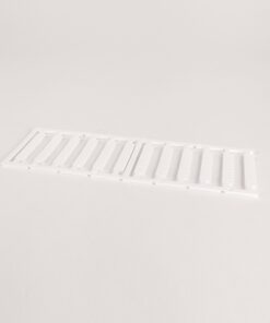 White plastic air vent grille with parallel rectangular slats lying on a pale surface