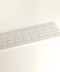 White plastic slotted panel with repeating curved rectangular openings on a light background, laid diagonally.