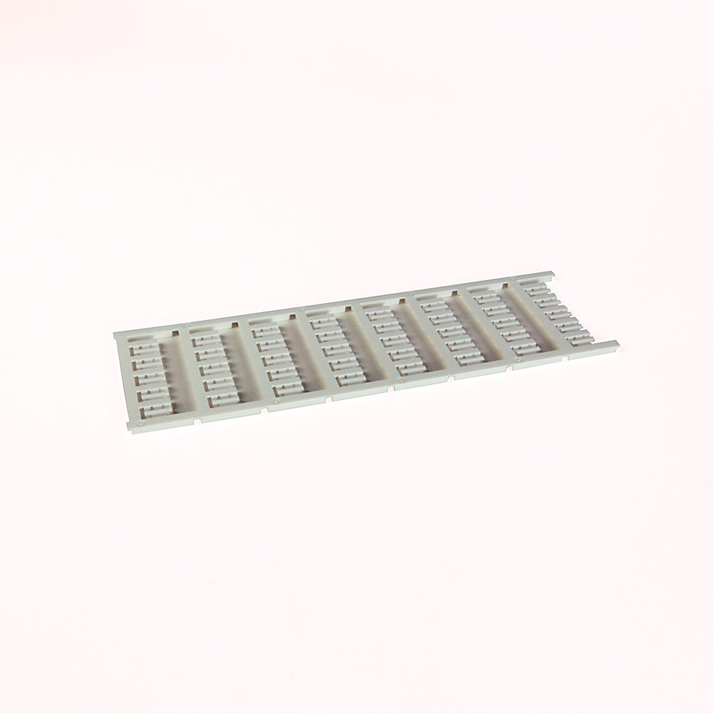 Long gray plastic slotted rack with many evenly spaced rectangular slots on a flat rail surface.