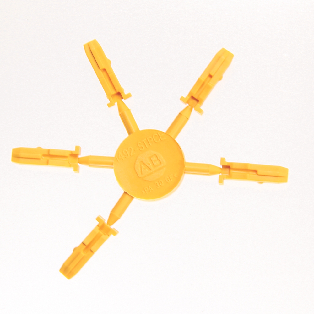 Six-armed yellow plastic star tool with clamp ends around a central circular hub.