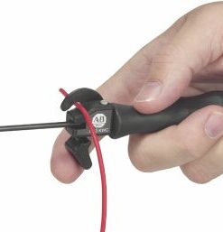 Close-up of a hand gripping a soldering iron with a metal tip and a red cord.