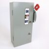 Gray metal electrical disconnect cabinet with an ON/OFF label and a red lever handle (industrial safety switch). Showcases a shutoff switch for equipment control, mounted on a light background.
