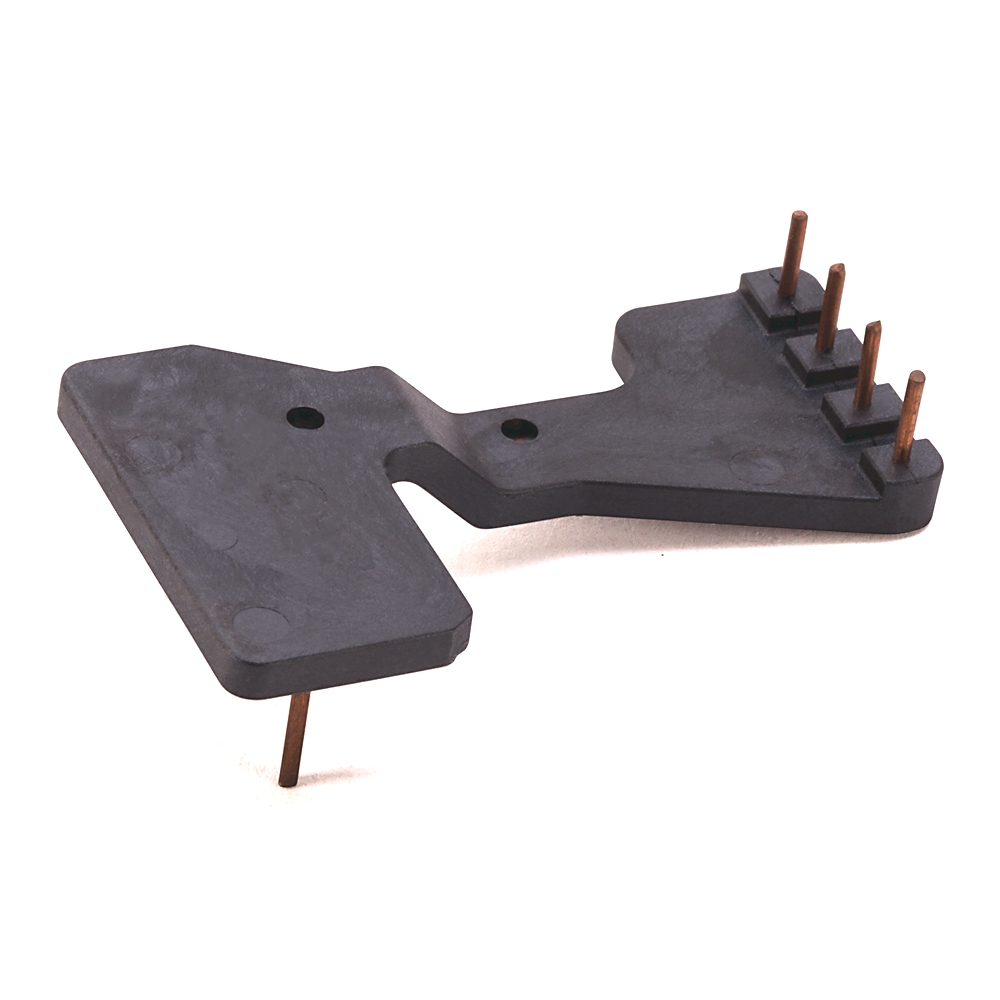 Black plastic mounting bracket with copper pins on one end and a single pin extending from the other side.
